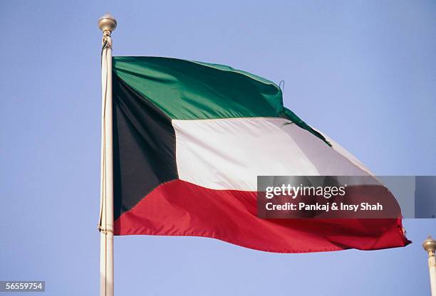 side view of a flag fluttering due to breeze. - kuwaiti flag - fotografias e filmes do acervo
