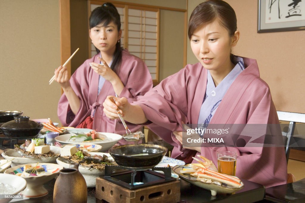 Two young women eating dinner in Japanese style inn