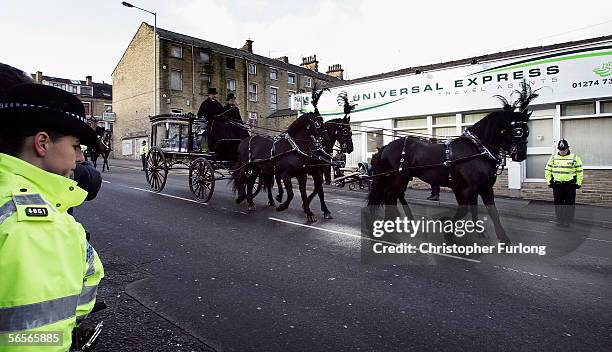 Police officers pay their respects to the funeral cortege of Police Constable Sharon Beshenivsky as it passes the scene of her murder in Morley...