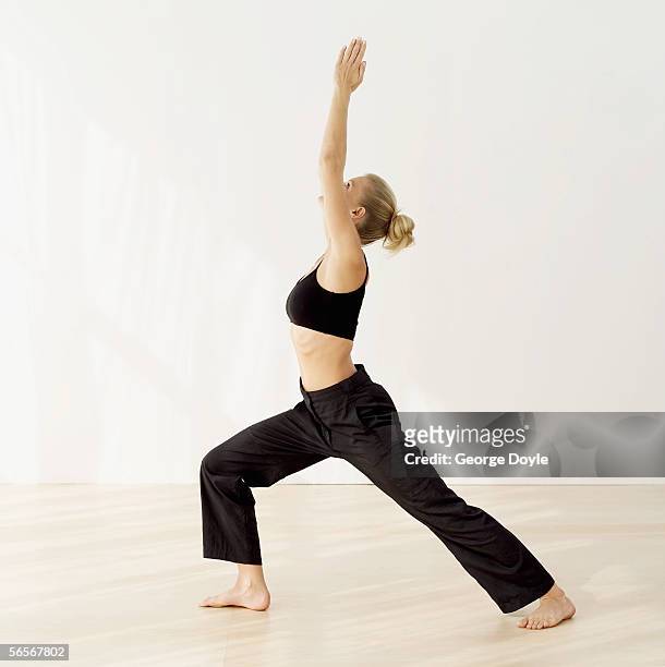 side profile of a young woman practicing yoga - tai chi imagens e fotografias de stock