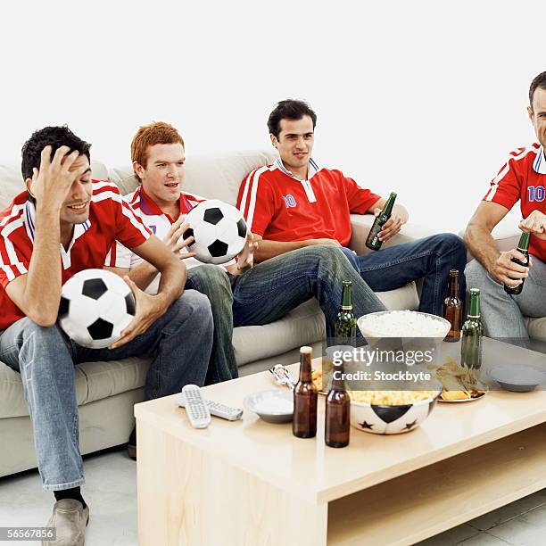 four young men wearing soccer jerseys - sports jersey home stock pictures, royalty-free photos & images