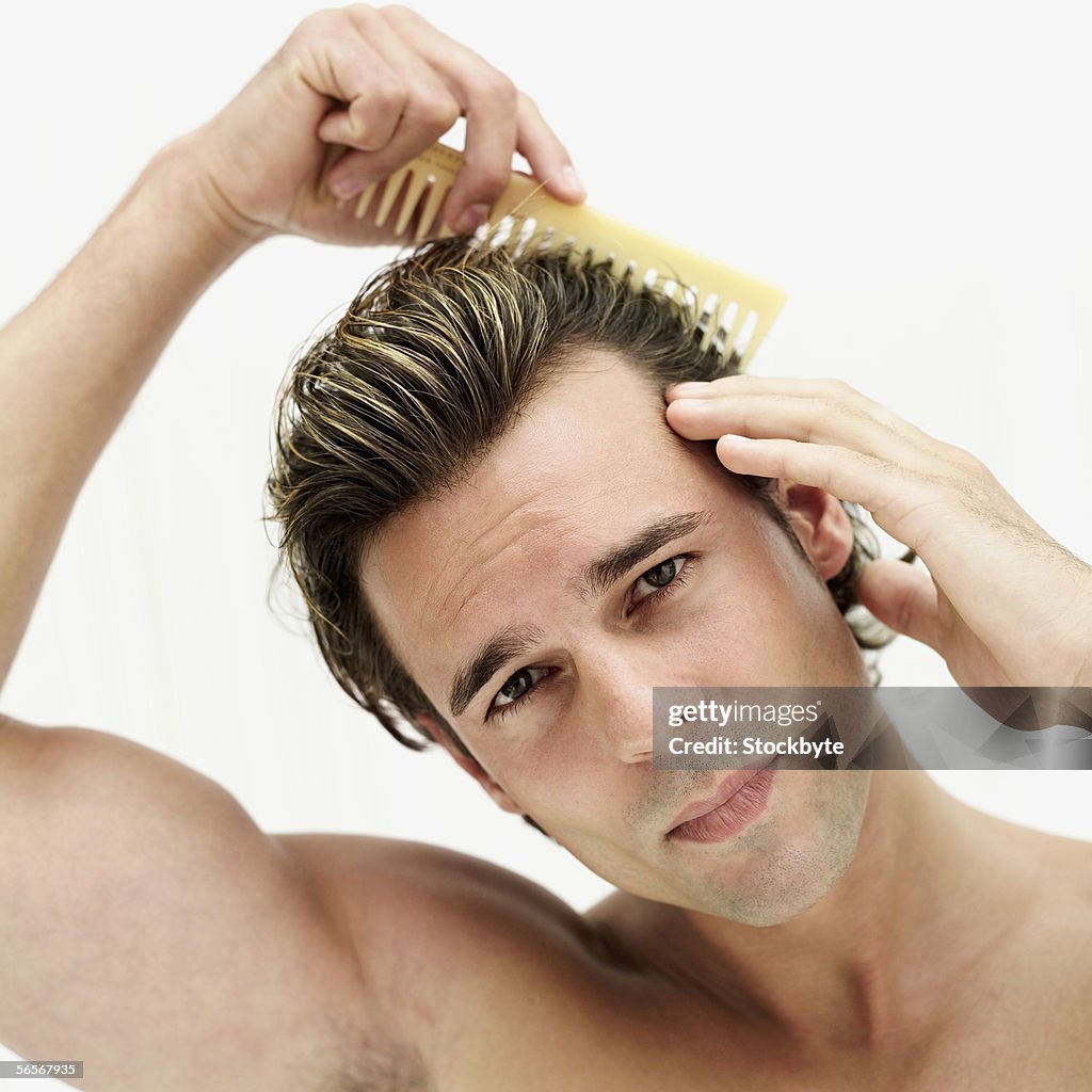 Portrait of a young man combing his hair