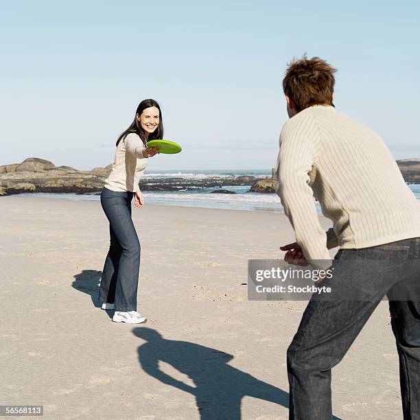 Playing Flying Disc On Beach Photos and Premium High Res Pictures ...