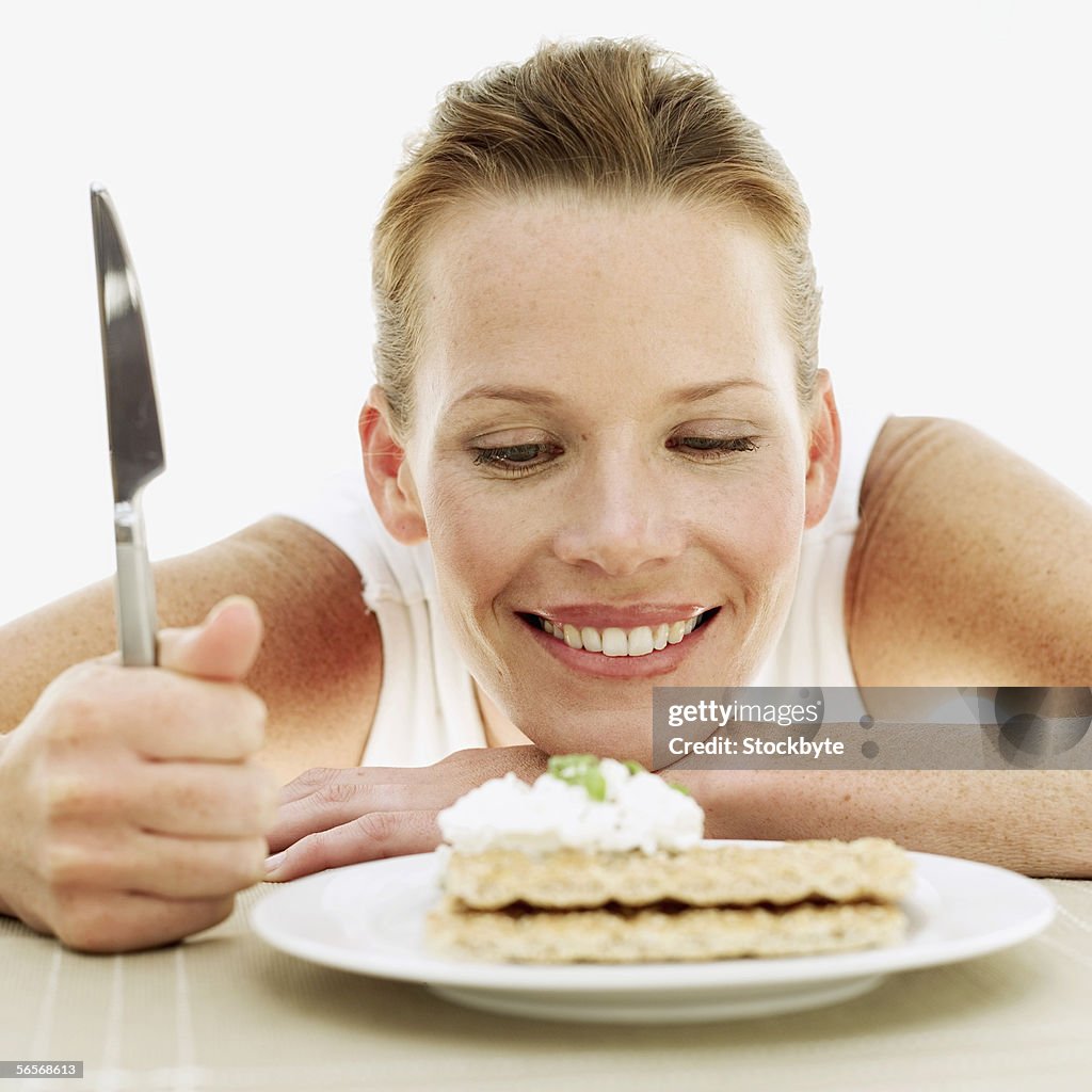 Young woman looking at a plate of sesame seed crackers with cream