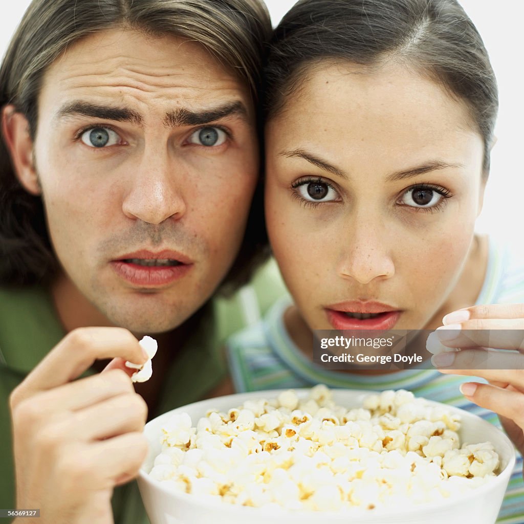 Close-up of a young couple holding a bowl of popcorn