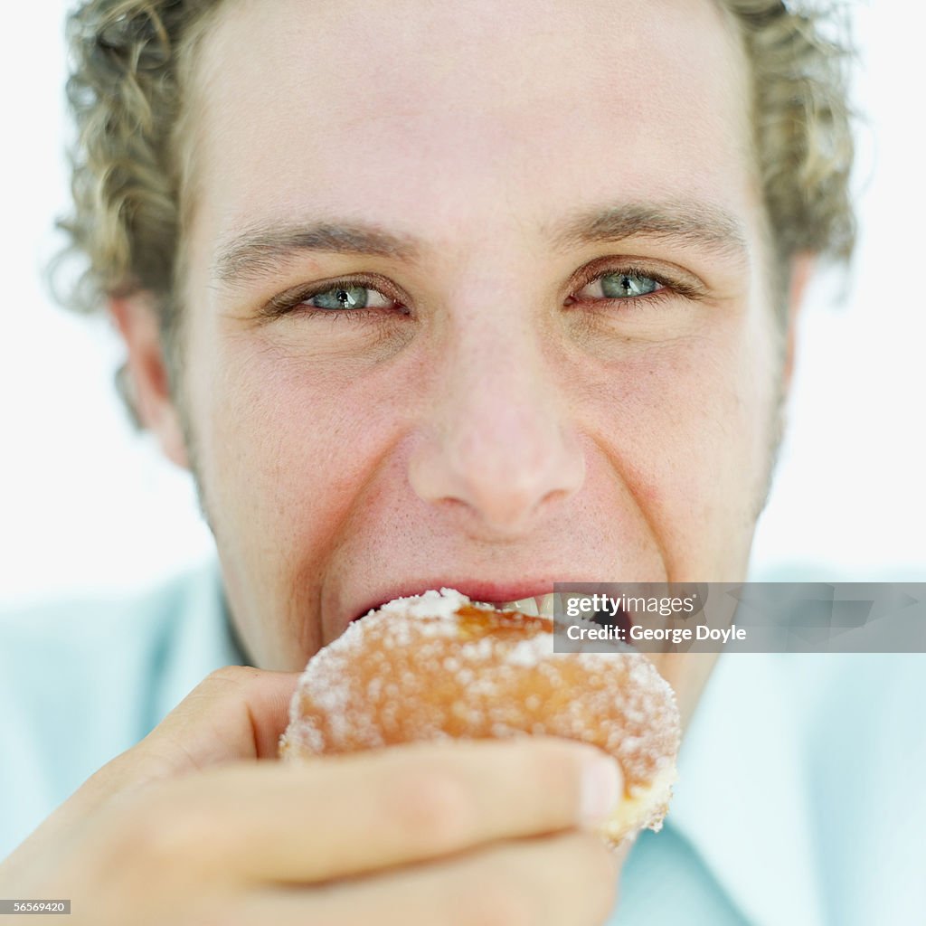 Close-up of a young man eating a donut