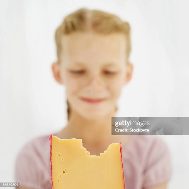 close-up of a girl holding a wedge of cheese - cheese wedge foto e immagini stock