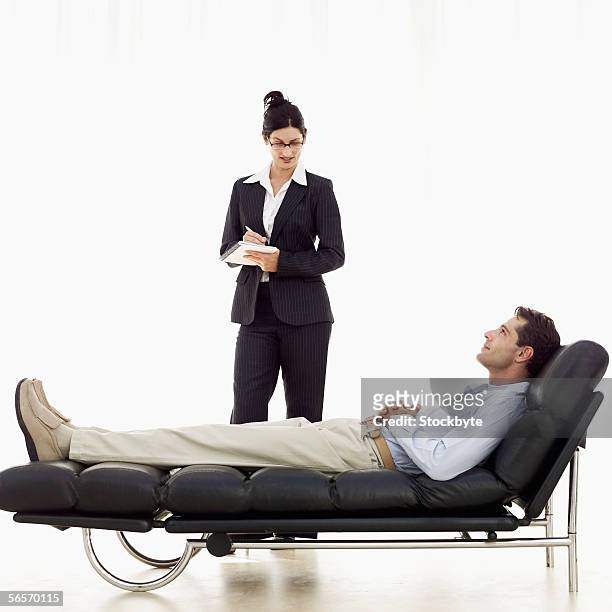 female psychiatrist listening to a patient on a sofa - psychiatrists couch fotografías e imágenes de stock