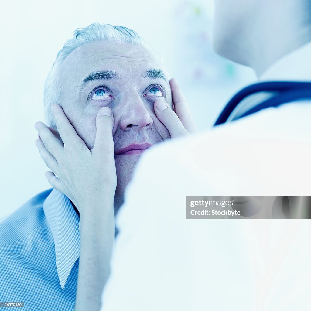 Close-up of a female doctor examining the eyes of a patient