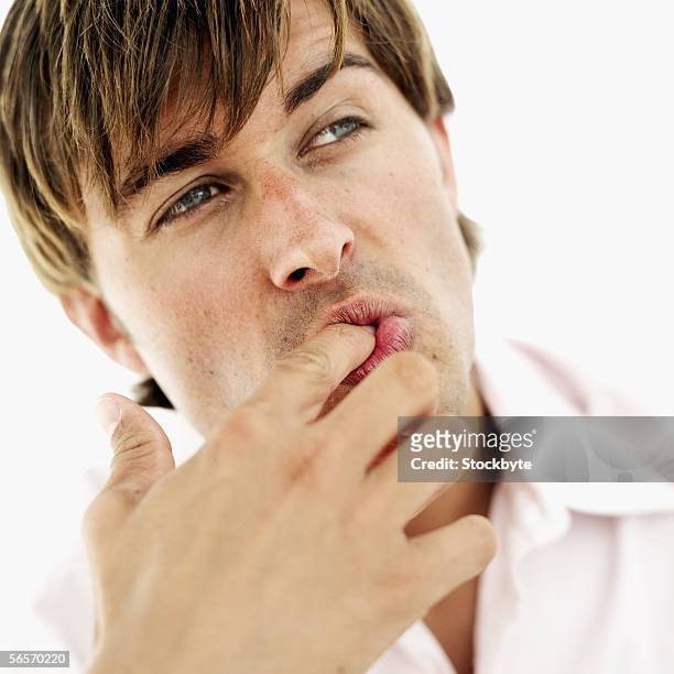 close-up of a young man licking his finger - finger in mouth stock pictures, royalty-free photos & images
