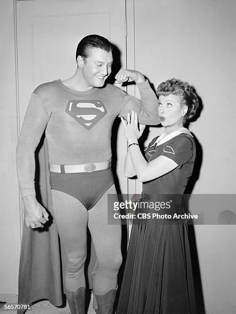 American actor George Reeves flexes his bicep while actress and comedian Lucille Ball touches his muscle during the episode 'Lucy and Superman' of...