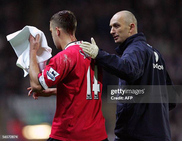 Wigan, UNITED KINGDOM: Manchester United's Alan Smith is led from the field with a bleeding head following a collision with Blackburn Rovers...