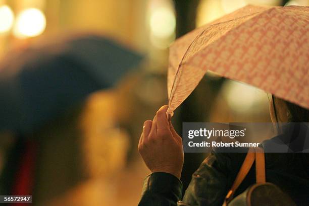 Commuter holds her umbrella while waiting for a bus in Rainier Square on 4th Avenue during evening rush hour January 10, 2006 in Seattle, Washington....