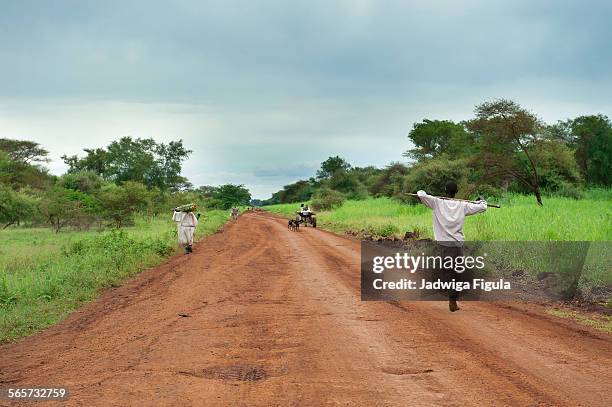 people walking on a dirt road in south sudan. - スーダン ストックフォトと画像