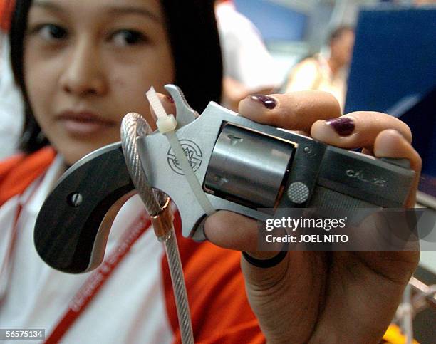 Saleslady shows off a locally made five-round 'Duchess .25 calibre' revolver at an arms show in Manila, 12 January 2006. More and more Filipinos are...