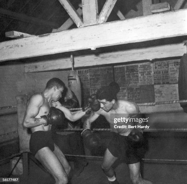 British middleweight boxing champion Randolph Turpin spars with his brother Dick , also a middleweight champ, 10th December 1949.