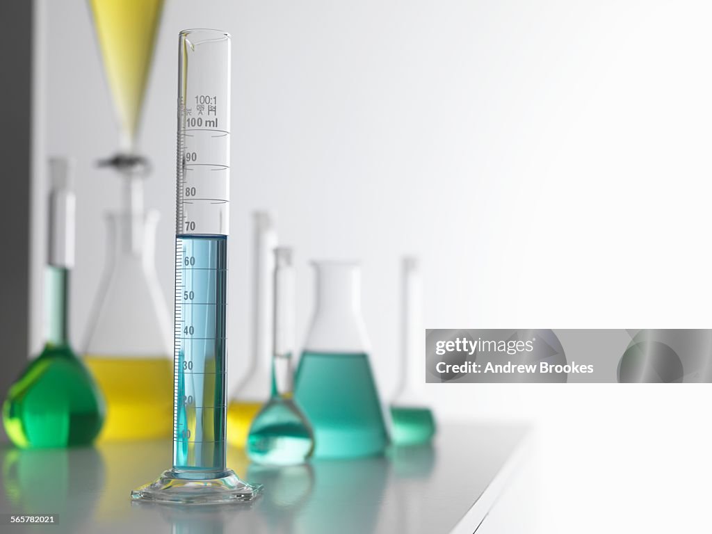 Laboratory glassware on lab bench with a graduated measuring cylinder in foreground