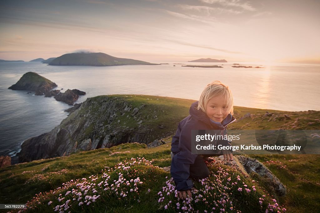 Young boy sitting on hillside, Slea head, County Kerry, Ireland