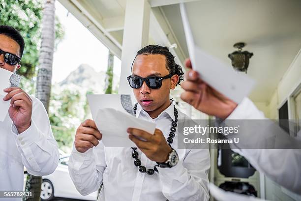 young men preparing for hawaiian wedding wearing kukui nut beads, kaaawa, oahu, hawaii, usa - hawaii hemd stock-fotos und bilder