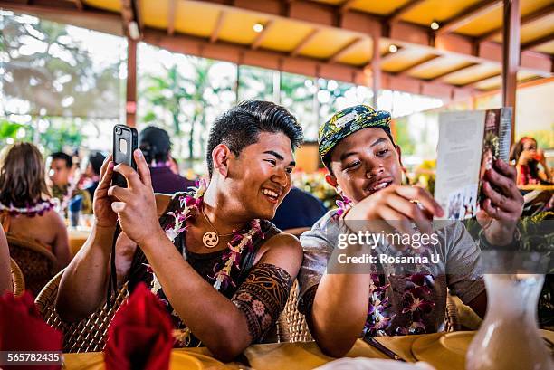 two young men reading menu in polynesian cultural centre, hawaii, usa - polinesische cultuur stockfoto's en -beelden