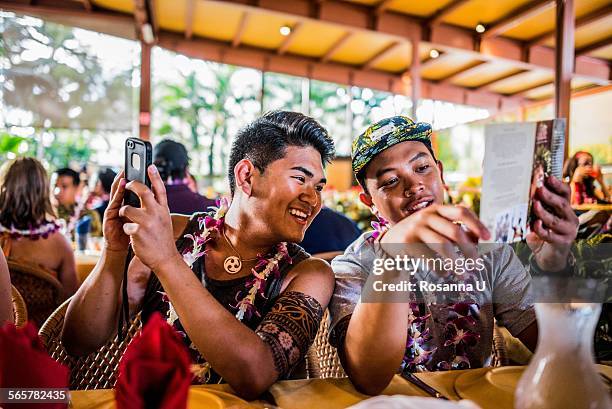 two young men reading menu in polynesian cultural centre, hawaii, usa - polinésia - fotografias e filmes do acervo