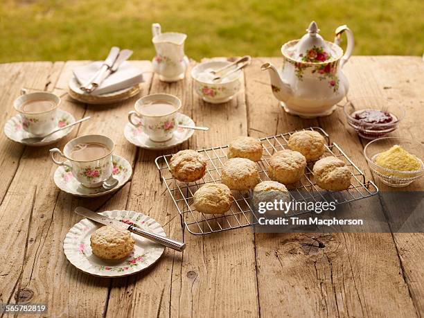 table with afternoon tea of with fresh baked scones with jam and clotted cream - english afternoon tea stock pictures, royalty-free photos & images