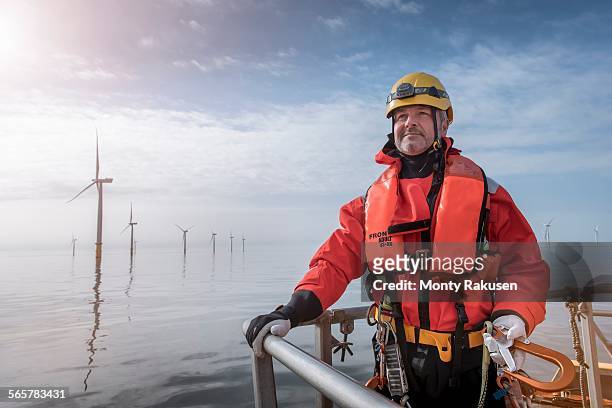 portrait of engineer on boat at offshore windfarm - life vest stock pictures, royalty-free photos & images