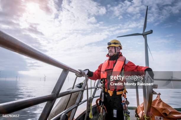 portrait of engineer on boat at offshore windfarm - monty rakusen portrait stock pictures, royalty-free photos & images