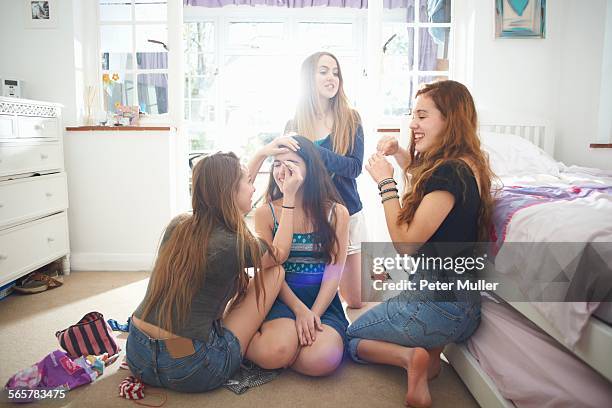 four teenage girls getting make up ready in bedroom - future party stock-fotos und bilder