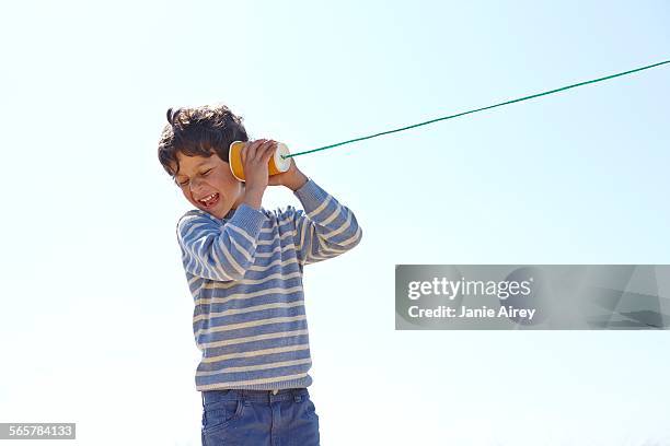 young boy, holding cup and string telephone to ear - string stock pictures, royalty-free photos & images