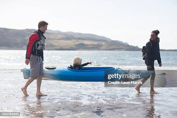 parents carrying son in canoe on beach, loch eishort, isle of skye, hebrides, scotland - carrying canoe stock pictures, royalty-free photos & images