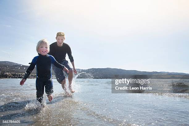 father and son running on beach, loch eishort, isle of skye, hebrides, scotland - scotland beach stock pictures, royalty-free photos & images