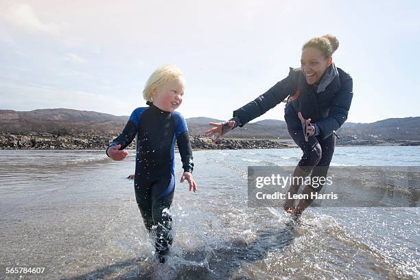 mother and son running on beach, loch eishort, isle of skye, hebrides, scotland - chase atlantic stock-fotos und bilder