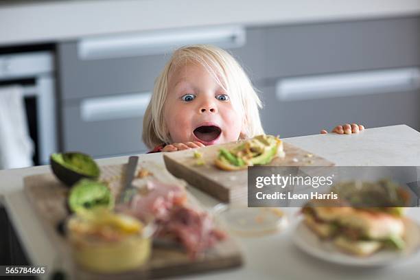 boy peeking over kitchen counter - kid peeking stock pictures, royalty-free photos & images