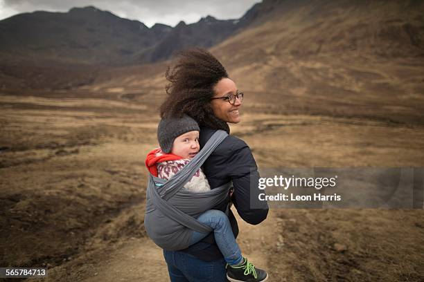 Mother carrying son in sling, Fairy Pools, near Glenbrittle, Isle of Skye, Hebrides, Scotland