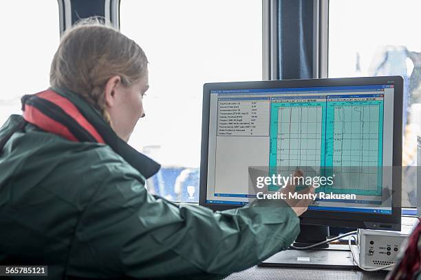 female scientist inspecting water data on research ship - marine scientist stock pictures, royalty-free photos & images