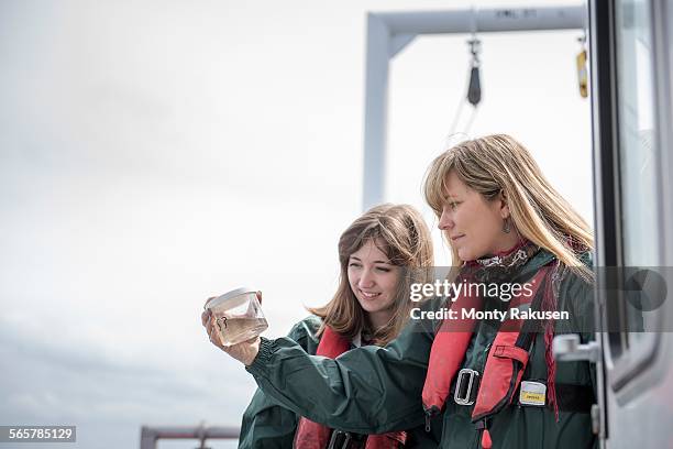 female scientists inspecting sample of plankton on research ship - learning environment stock pictures, royalty-free photos & images