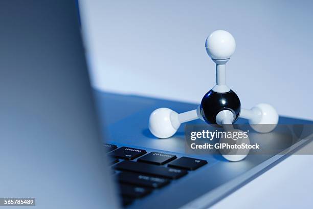 methane molecule model and a laptop computer. methane is the simplest hydrocarbon and is a main constituent of natural gas - hydrocarbon stock-fotos und bilder