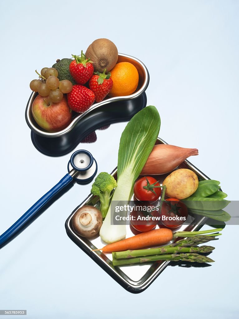 Stethoscope between trays of fresh fruits and vegetables