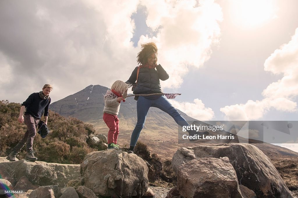 Family walking over boulders, Fair Pools, Isle of Skye, Hebrides, Scotland