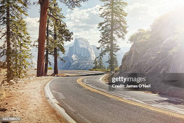 winding road with half dome in yosemite - road view stock-fotos und bilder