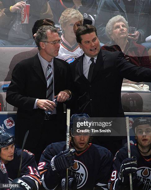 Head Coach Craig MacTavish and Assistant Craig Simpson of the Edmonton Oilers discuss strategy against the Chicago Blackhawks behind the bench during...