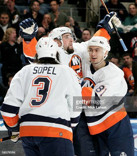 Brent Sopel and Miroslav Satan of the New York Islanders congratulate team mate Trent Hunter after his goal against the Calgary Flames on January 12,...