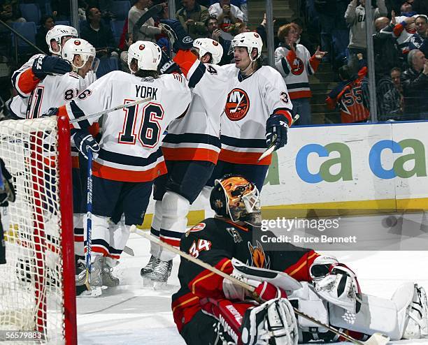 Goaltender Miikka Kiprusoff of the Calgary Flames looks at the scoreboard after Miroslav Satan of the New York Islanders ties the score at 2-2 at...