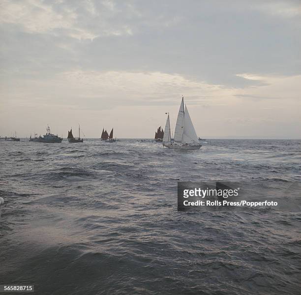 Accompanied by a flotilla of boats, British sailor Francis Chichester steers his yawl Gipsy Moth IV, in foreground, towards Plymouth, England on 28th...