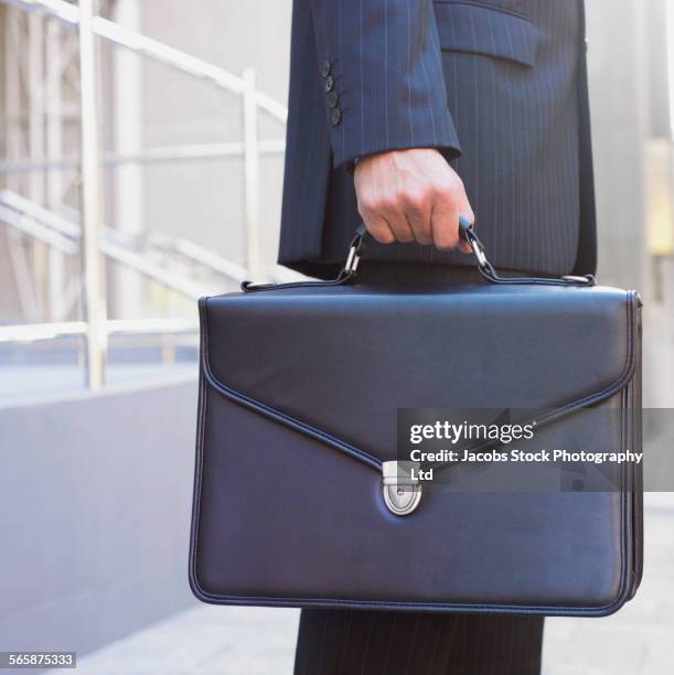 hispanic businessman carrying briefcase - attaché stockfoto's en -beelden