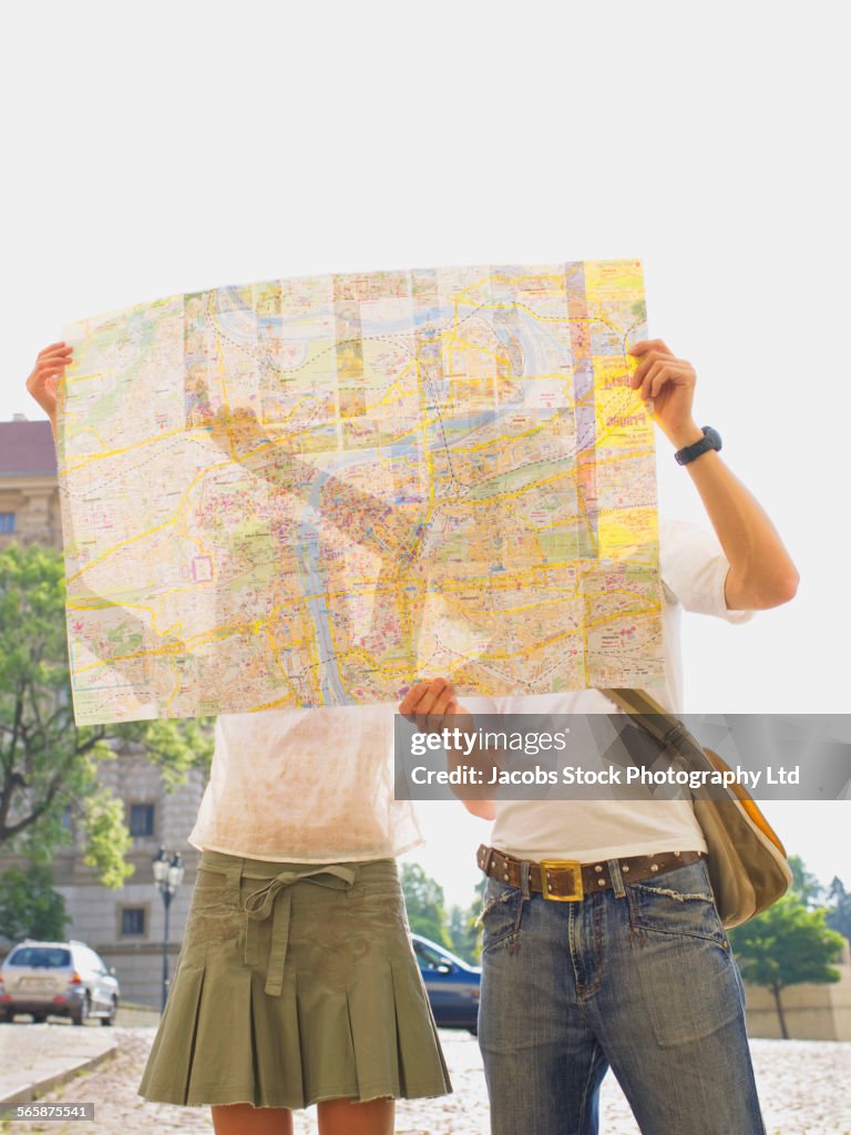 Caucasian couple reading city map outdoors