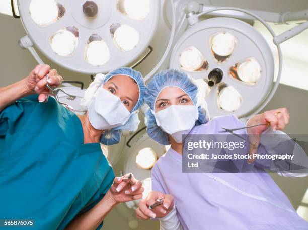 nurses holding equipment in hospital operating room - funny surgical masks stock pictures, royalty-free photos & images