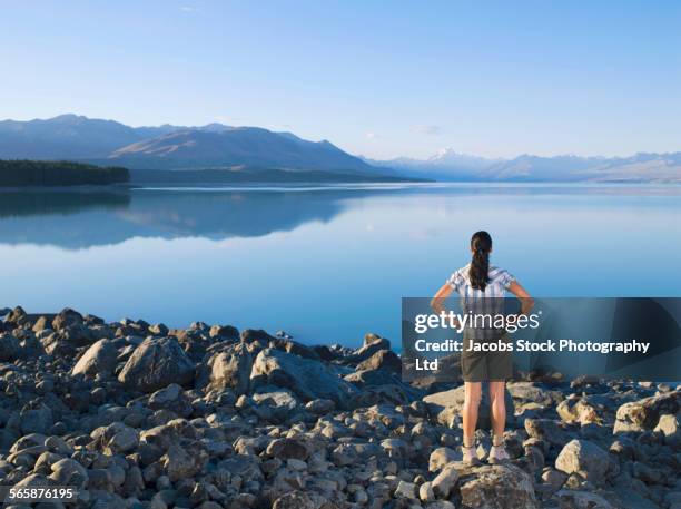 hispanic woman admiring remote lake - lakeshore stock pictures, royalty-free photos & images
