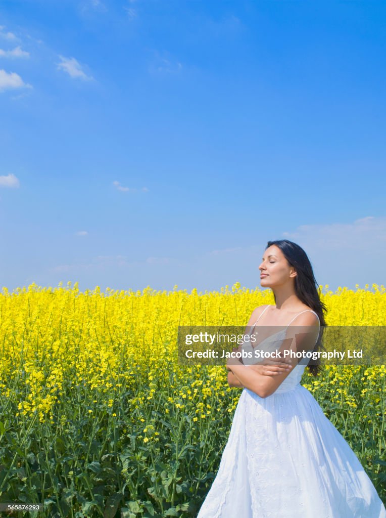 Indian woman standing in field of flowers